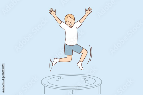Teenage boy jumps on trampoline enjoying outdoor activities and exercising in gym