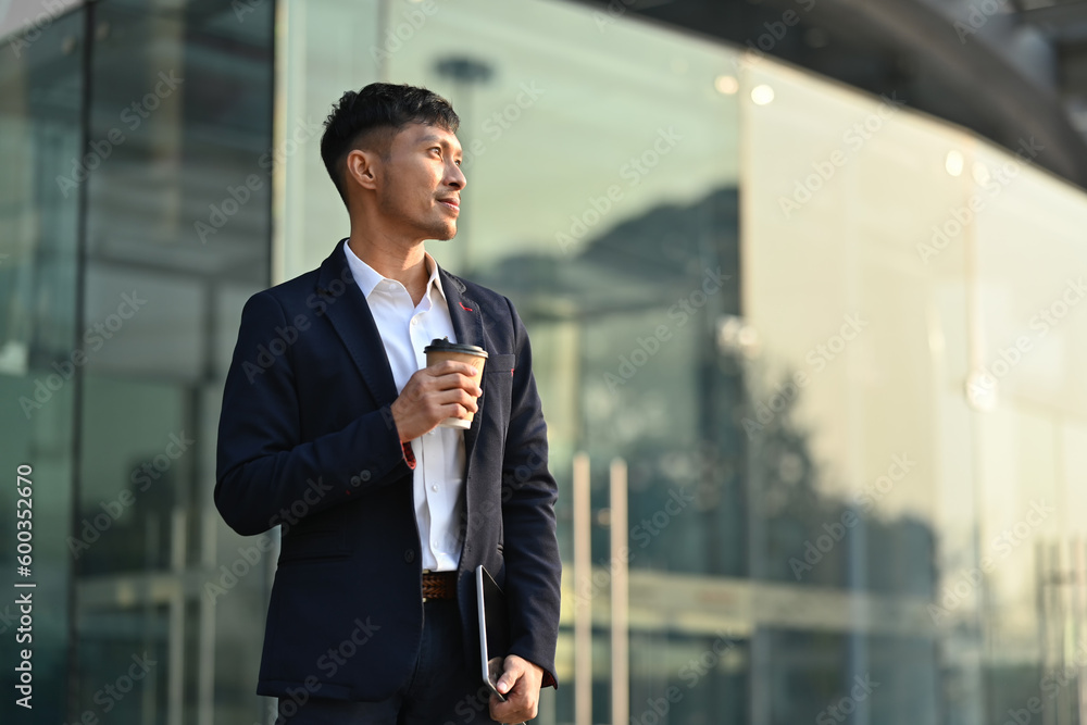 Portrait of successful businessman holding takeaway coffee cup standing outdoor with sunlight in early morning Portrait of successful businessman holding takeaway coffee cup standing outdoor with sunlight in early morning