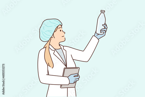 Woman laboratory assistant with glass bottle checks chemical composition of milk produced in factory