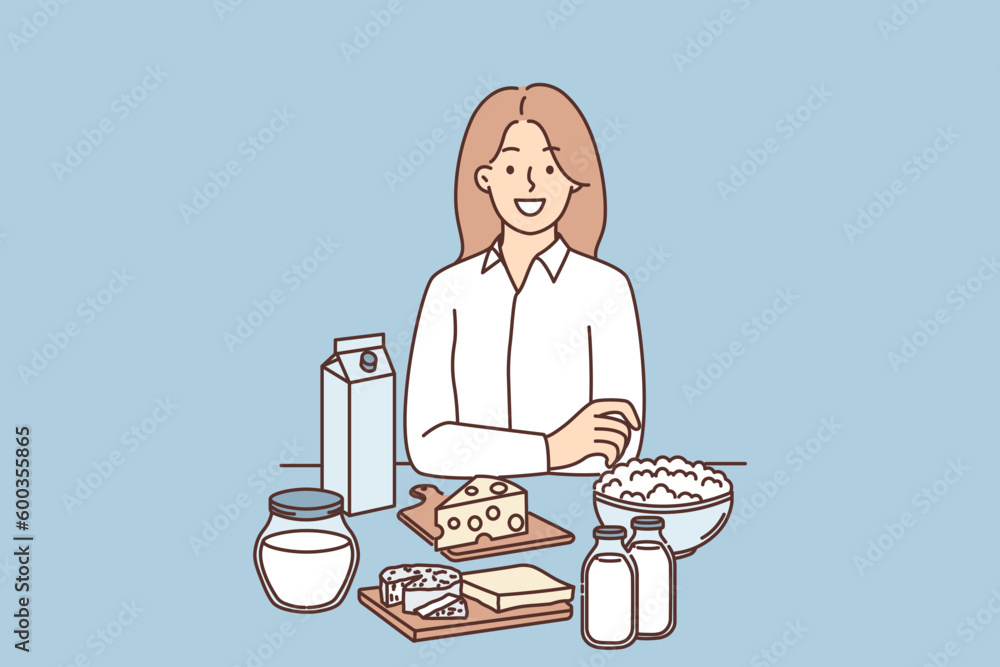 Woman is standing near table with dairy products and yogurt or cheese high in lactose and nutrients Woman is standing near table with dairy products and yogurt or cheese high in lactose and nutrients