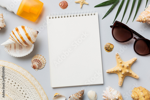 Blank writing book with summer beach accessories on background, copy space. Flat lay with copy space