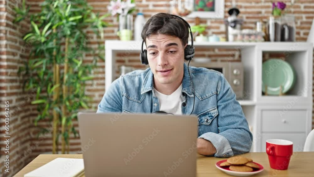 Young hispanic man having online lesson taking notes at dinning room Young hispanic man having online lesson taking notes at dinning room