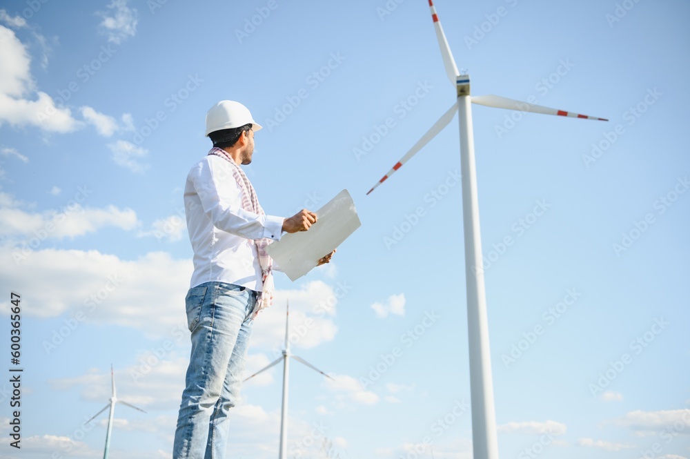 Indian Engineer in wheat field checking on turbine production Indian Engineer in wheat field checking on turbine production