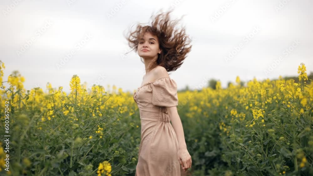 Free girl running happily through rapeseed field, agriculture, childhood dream concept. farm girl, happy young beautiful pretty woman running in field, turning to camera, long brown hair blowing Free girl running happily through rapeseed field, agriculture, childhood dream concept. farm girl, happy young beautiful pretty woman running in field, turning to camera, long brown hair blowing
