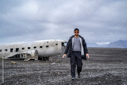 Obraz na płótnie man walking away from United States Navy DC plane on the black beach at Sólheimasandur w salonie
