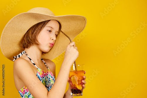 Child teenager girl in swimsuit and straw hat with lemonade