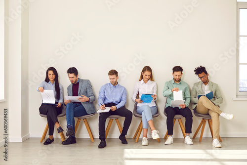 Photos Diverse young people sitting in row waiting for job interview