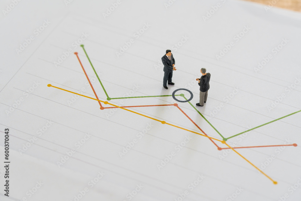 Financial or investment price concept, Miniature professional businessmen standing and looking, review on stock market data graph. Data analysis documents and business meetings Financial or investment price concept, Miniature professional businessmen standing and looking, review on stock market data graph. Data analysis documents and business meetings