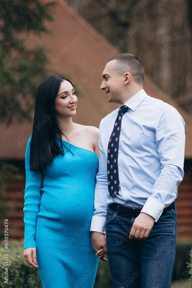 pregnant woman with her husband walking together in the park. married couple