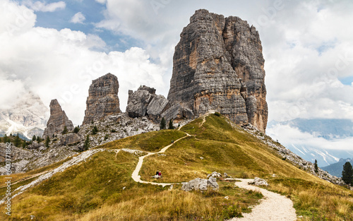 Cinque Torri rock formation with the path in the foreground. Mountain trail leading to the 5 Torri with a few tourists enjoying the hike. Place of interest near Cortina d'Ampezzo in Dolomites, Italy. photo