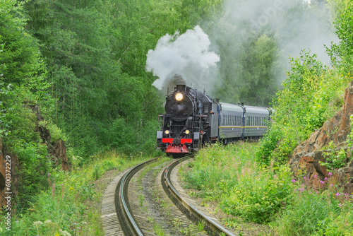 Retro steam train moves at summer morning.