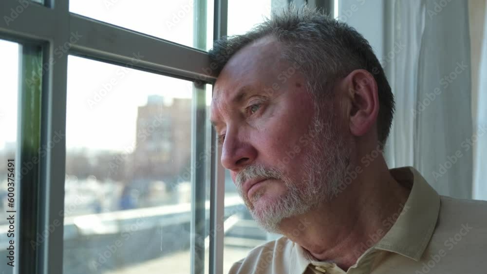 Sad tired lonely disappointed older senior man at home alone. Unhappy grandfather looking sadly outside window experiencing grief relative death bad news. Stressed elder man suffering from loneliness Sad tired lonely disappointed older senior man at home alone. Unhappy grandfather looking sadly outside window experiencing grief relative death bad news. Stressed elder man suffering from loneliness