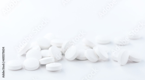 Round white pills, close-up on a white background. Medical and pharmaceutical subjects.