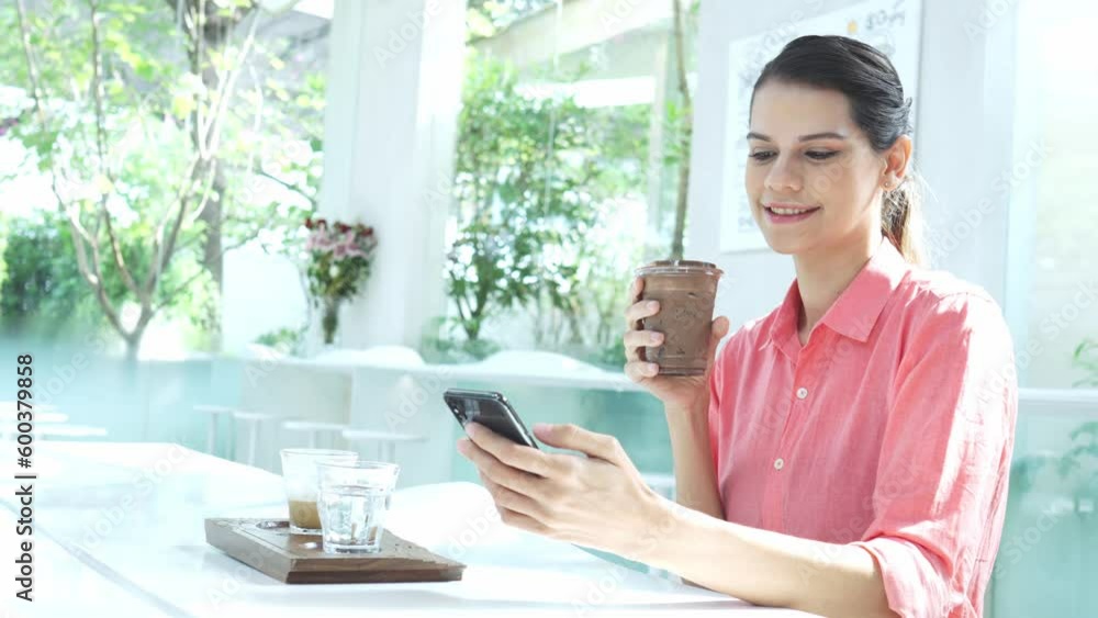 Smiling beautiful young lady sending text messages on mobile phone in Cafes. Smiling beautiful young lady sending text messages on mobile phone in Cafes.