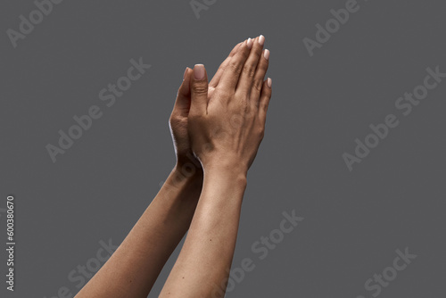 Female hands showing gesture of praying against grey background. Social issues, freedom of speech, equality. Concept of human relation, community, togetherness, symbolism, culture, communication