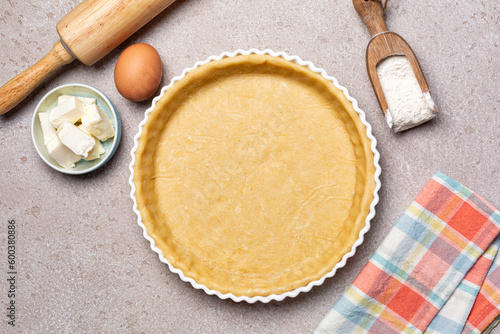 Raw, unbaked butter pie crust with ingredients for recipe, ehh, flour, butter, homemade pie dough. Top view. photo