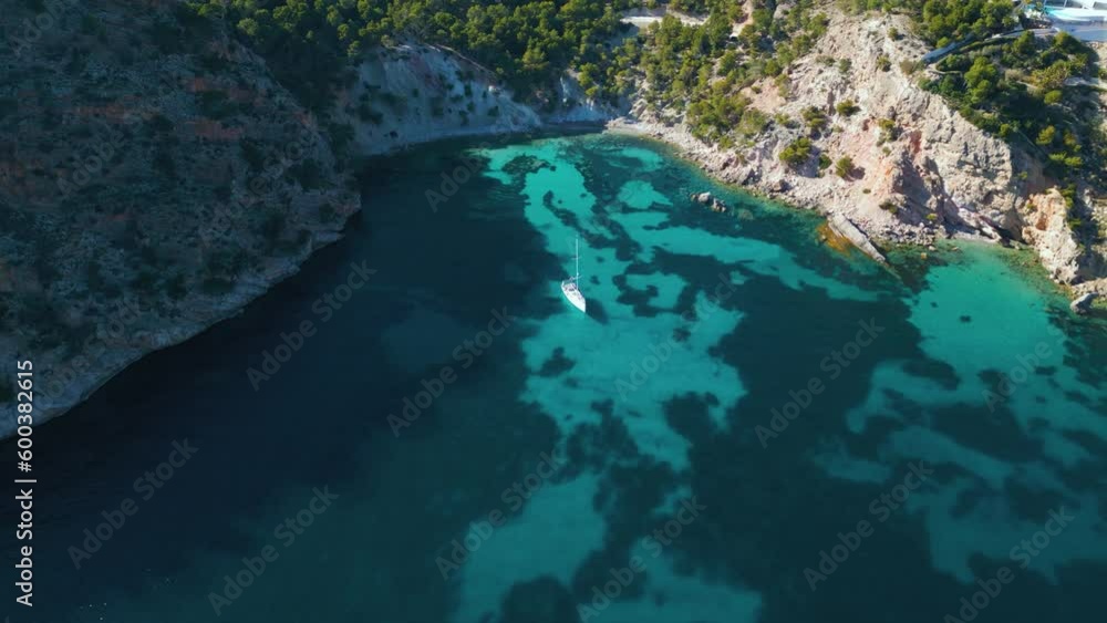 Pristine clear turquoise water beach bay with yacht ship sailing boat at on Palma de Mallorca Island. Natural idyllic seaside cliff coast. Circling cinematic aerial drone 4K UHD. Majorca, Spain. Pristine clear turquoise water beach bay with yacht ship sailing boat at on Palma de Mallorca Island. Natural idyllic seaside cliff coast. Circling cinematic aerial drone 4K UHD. Majorca, Spain.