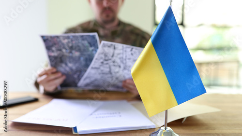 Military man holding in hands secret plans of Ukrainian counteroffensive operation closeup photo