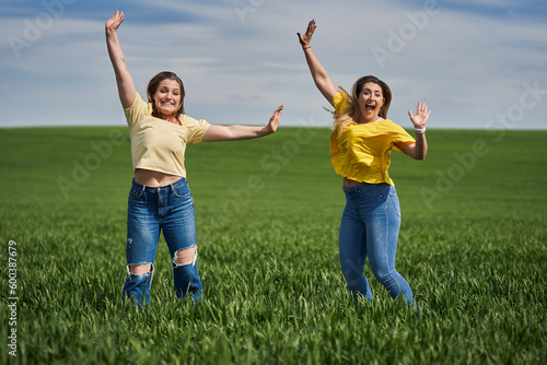 Plus size girls jumping for joy in a wheat field