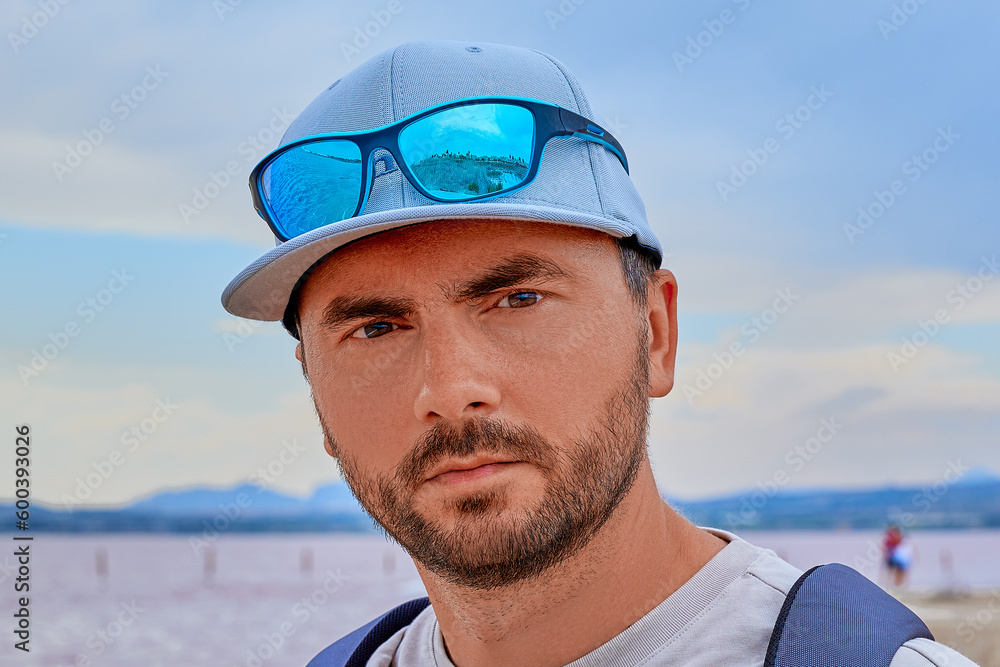 Portrait of a pensive swarthy man with a dark beard. In a cap and with sunglasses. Portrait of a pensive swarthy man with a dark beard. In a cap and with sunglasses.