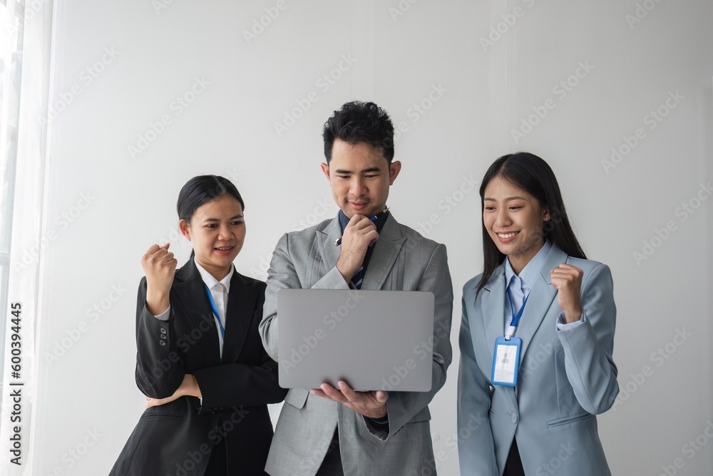 Asian business groups are feeling happy and successful. Laughing hands up celebrating achievements on job goals deal with laptop Asian business groups are feeling happy and successful. Laughing hands up celebrating achievements on job goals deal with laptop