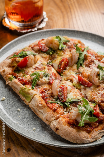 Pizza with seafood and arugula close-up