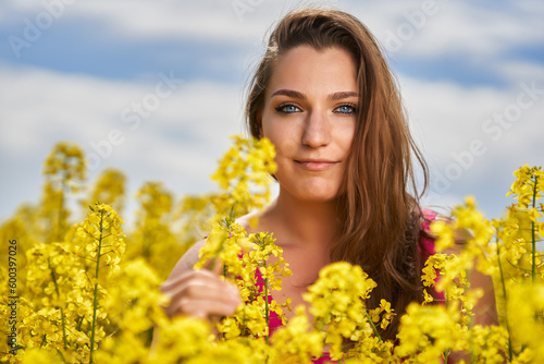 Beautiful woman with blue eyes in a canola field