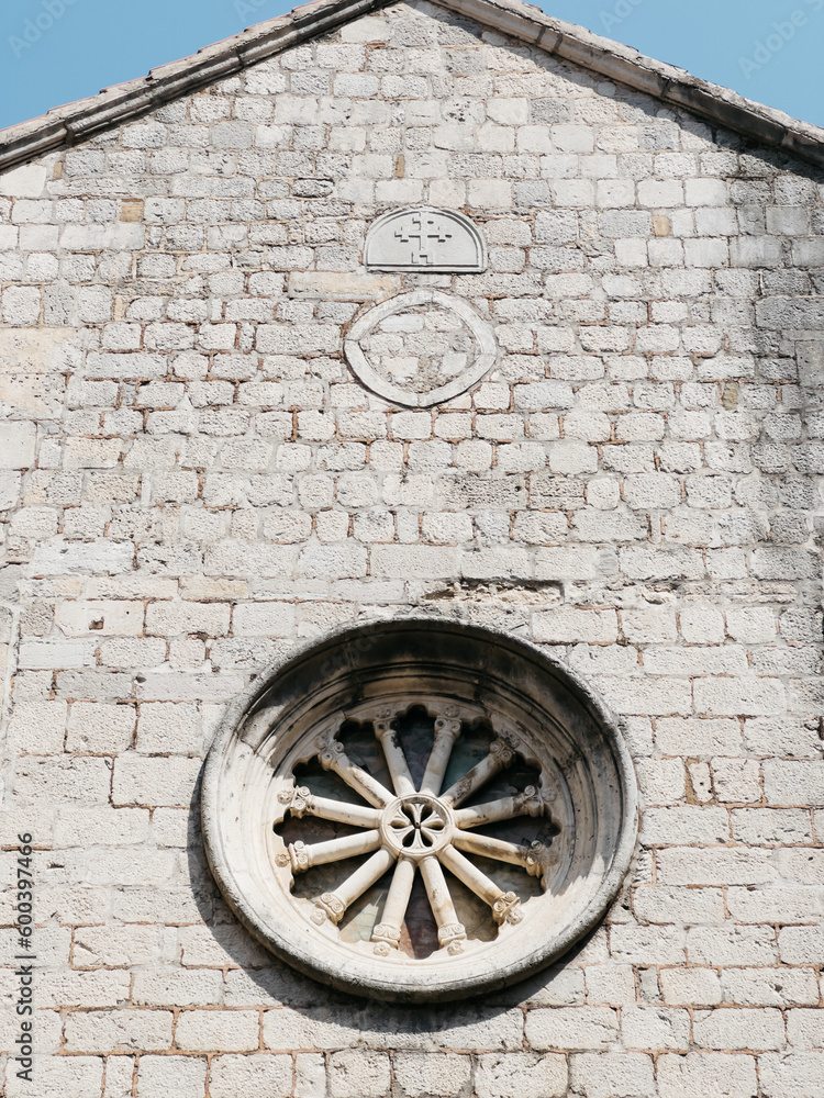 Rose window on the stone wall of an old church