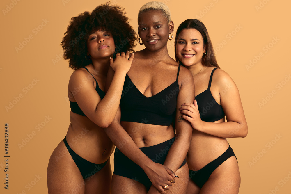 Positive multiracial women in lingerie looking at camera together