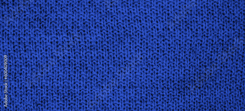 Texture of knitted wool fabric with of a blue color. Top view. Close-up. Banner. Selective focus.