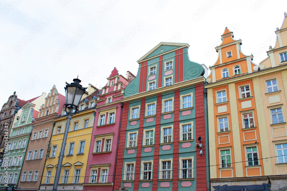 Fototapeta premium City view of the old buildings with colorful walls, decorative elements on the facades and lantern. Central square, old market with historical buildings. Old town. Poland, Wroclaw, January 2023