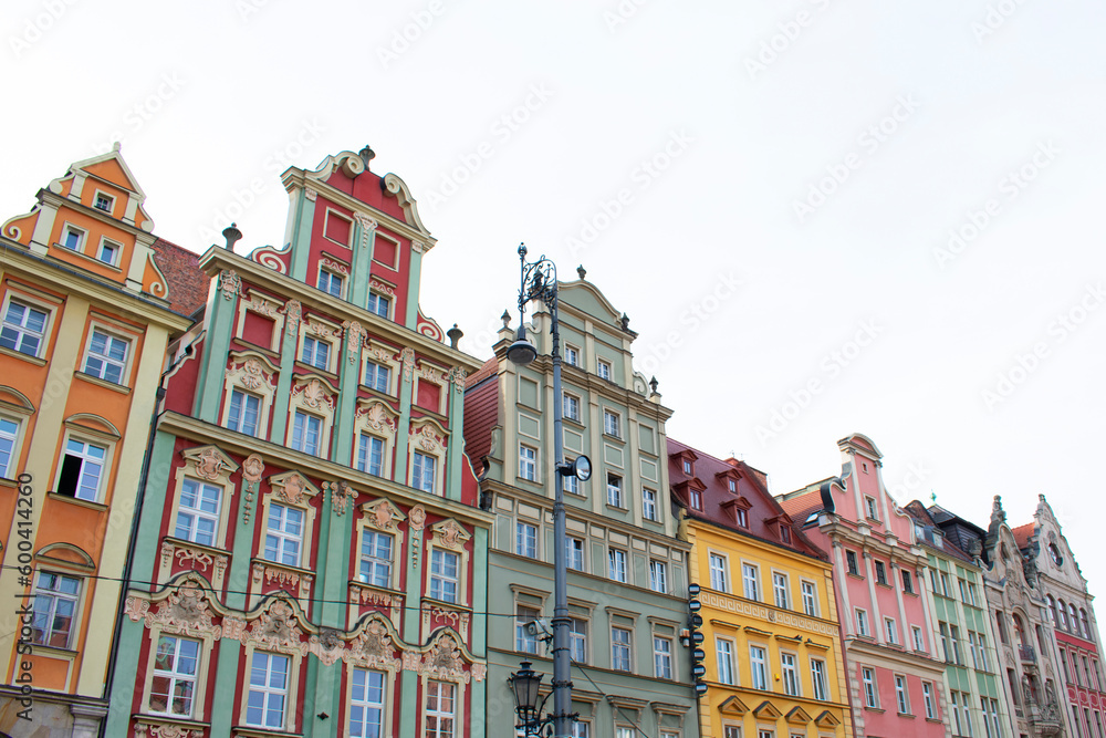 Fototapeta premium City view of the old buildings with colorful walls, decorative elements on the facades and lantern. Central square, old market with historical buildings. Old town. Poland, Wroclaw, January 2023.