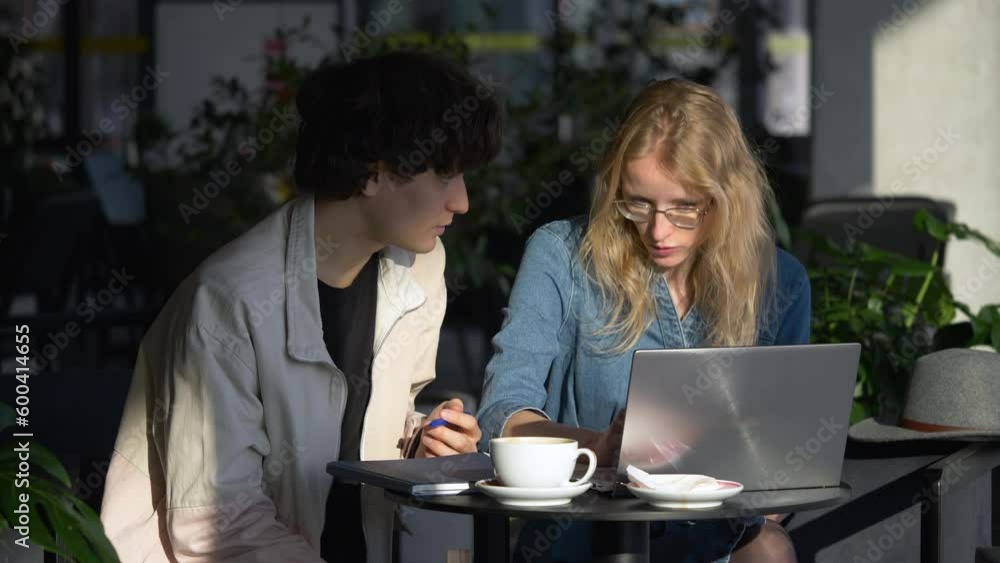 Man and woman discussing what furniture they need to order for apartment update. Couple sits next to the table and search for vacation directions. Man and woman discussing what furniture they need to order for apartment update. Couple sits next to the table and search for vacation directions.