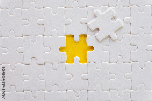 The last piece of missing jigsaw puzzle over yellow background use for mission,success,goal,target idea.