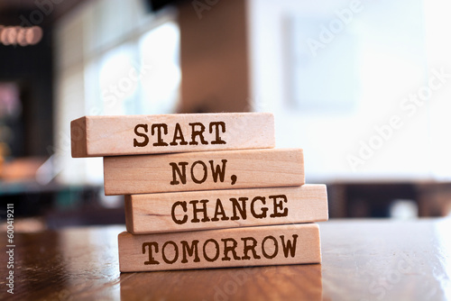 Wooden blocks with words 'Start now, change tomorrow'.