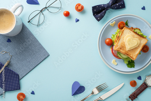 Show Dad your love with a special breakfast idea. Top view of a homemade sandwich, cutlery, coffee, napkin, tie, spectacles, bow-tie, on a pastel blue background with an empty frame for text or advert