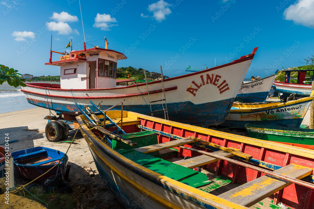 Local boats on Matadeiro beach and ocean in sunny day. Colorful boats on beach in Florianopolis