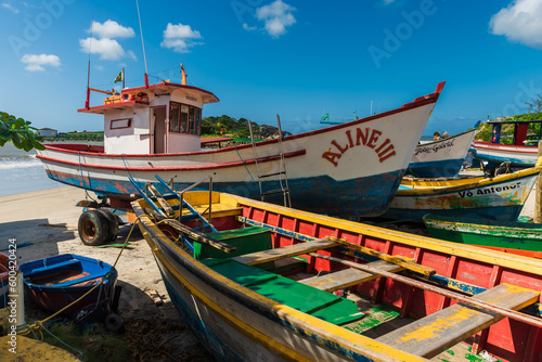 Local boats on Matadeiro beach and ocean in sunny day. Colorful boats on beach in Florianopolis photo