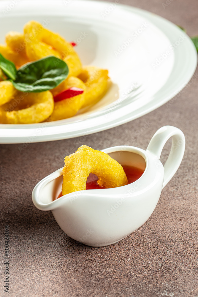 Delicious fried squid rings with sweet chilli sauce, vertical image. top view. place for text Delicious fried squid rings with sweet chilli sauce, vertical image. top view. place for text