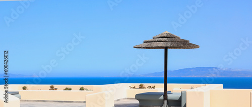 Tropical of summer with umbrella on the beach with blue ocean as summer tropical and blue sky background in Santorini Greece