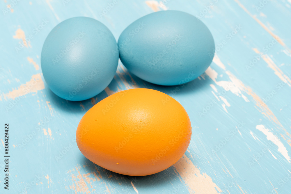Eggs symbolizing the Easter holiday in blue and orange color on a background of aged wood Eggs symbolizing the Easter holiday in blue and orange color on a background of aged wood