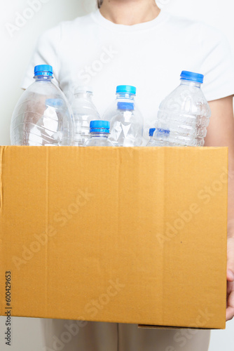 Volunteer keep plastic bottle into paper box at home or office. Hand Sorting Recycle garbage. Ecology, Environmental, pollution, Dispose recycling, waste management and trash Separation concept © Jo Panuwat D