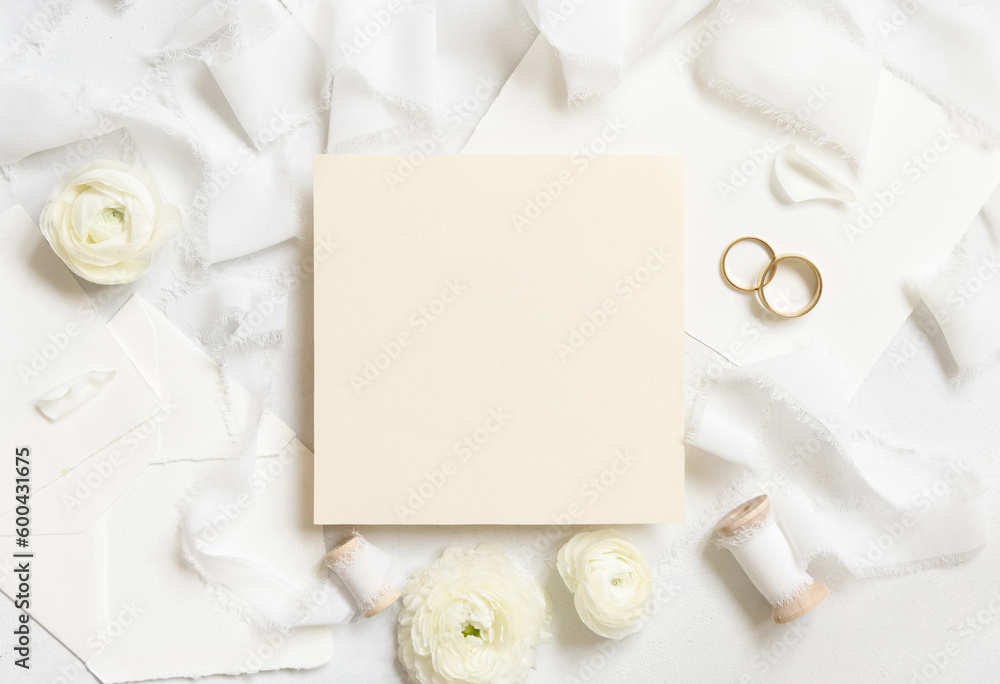 Blank card near cream roses, white silk ribbons and wedding rings top view, wedding mockup Blank card near cream roses, white silk ribbons and wedding rings top view, wedding mockup