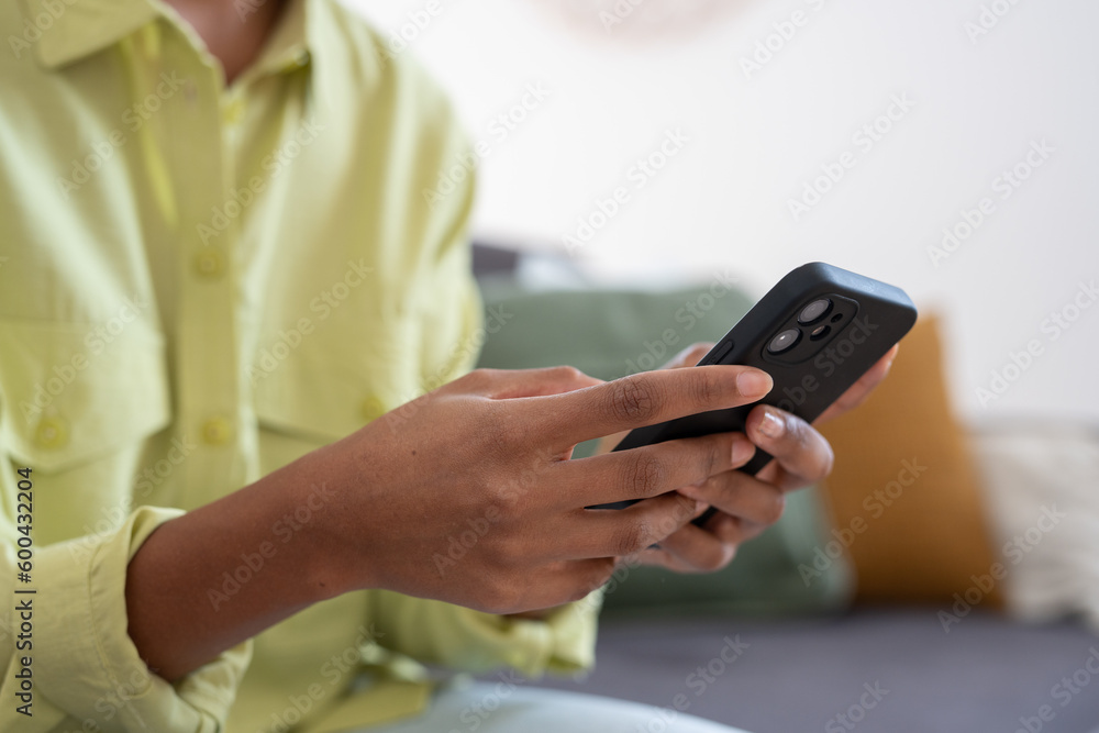 Hands of young dark skinned woman with finger rings using online app on mobile phone, making call, browsing Internet, chatting on social media, holding cellphone, texting, typing message. Close up. Hands of young dark skinned woman with finger rings using online app on mobile phone, making call, browsing Internet, chatting on social media, holding cellphone, texting, typing message. Close up.