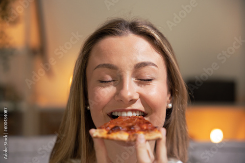 Blonde young woman eating pizza