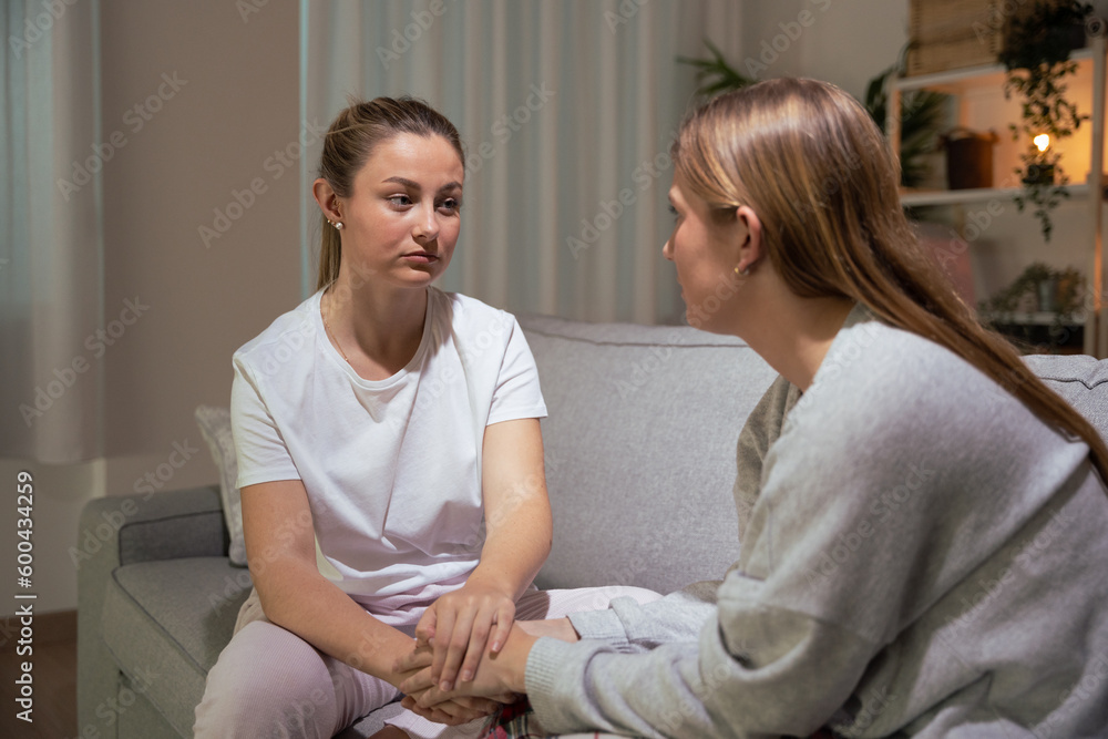 Serious young woman comforting sister Serious young woman comforting sister