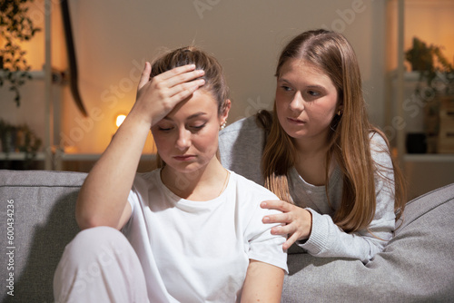 Teenager girl consoling sister at night