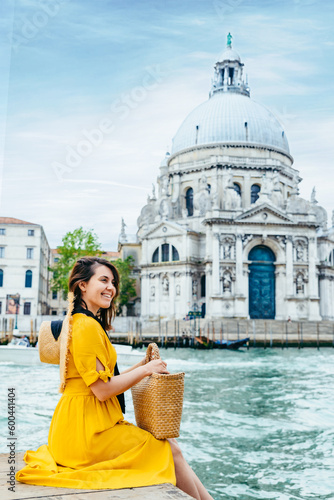 woman in yellow sundress sitting on pier with view of grand canal © phpetrunina14