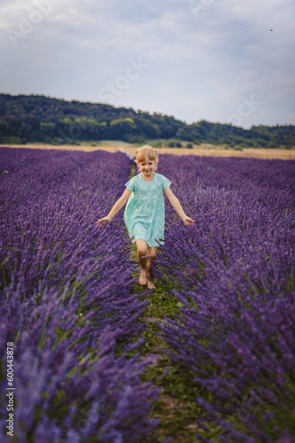 a girl runs across a lavender field
