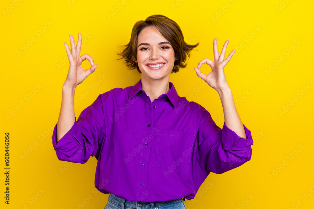 Photo of pretty businesswoman show okey symbols two hands good mood wear elegant blouse isolated yellow color background Photo of pretty businesswoman show okey symbols two hands good mood wear elegant blouse isolated yellow color background